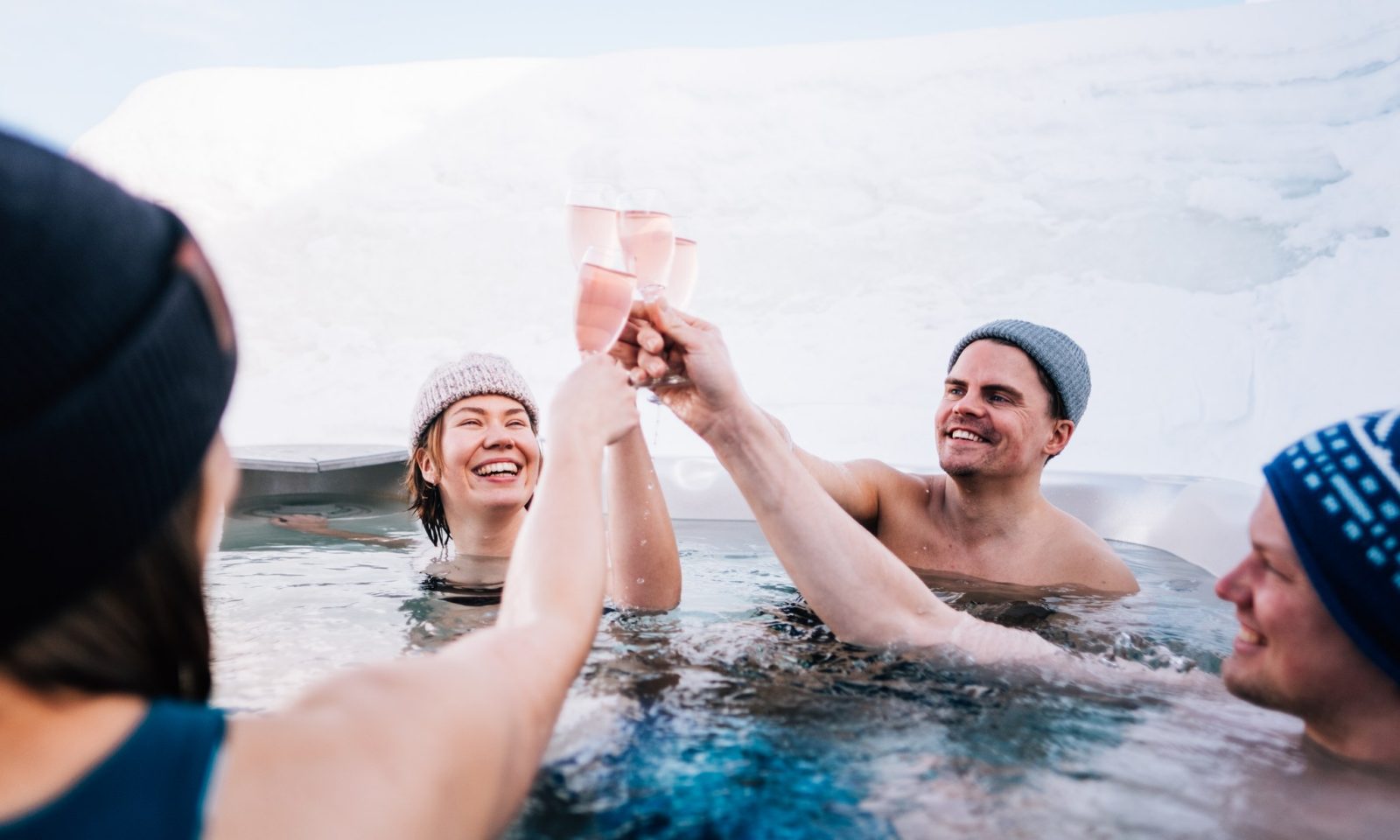 People in the outdoor jacuzzi surrounded by snow