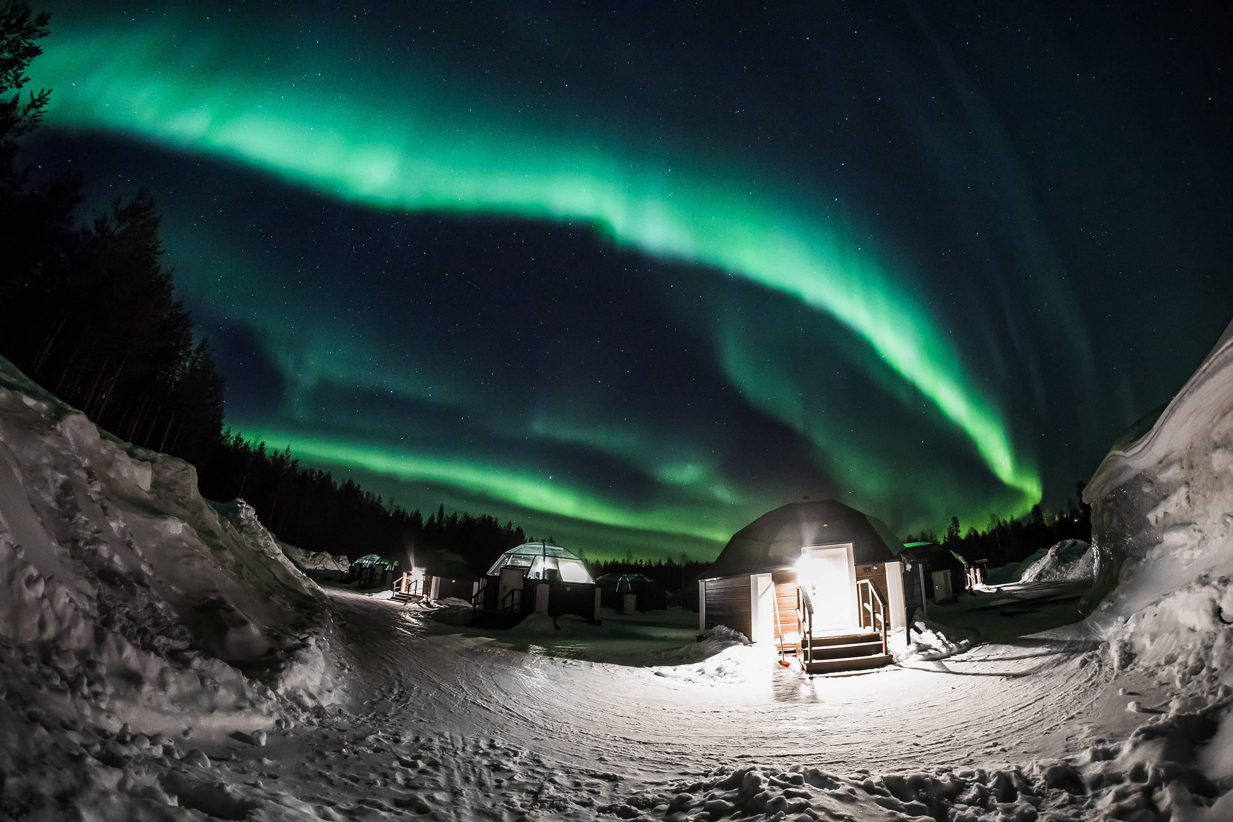 Revontulet lasi-iglujen yllä