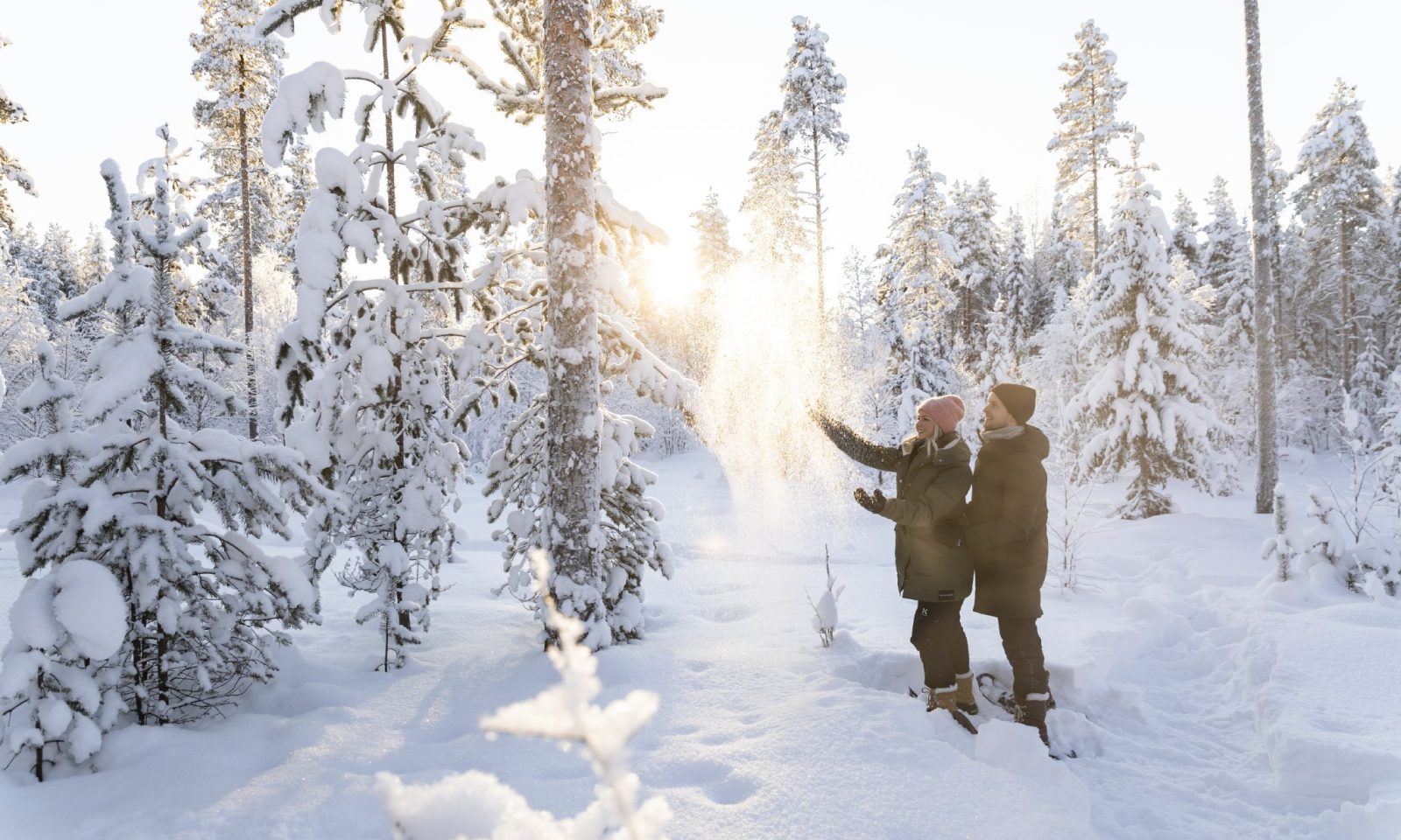 A couple snowshoeing in wintery forest in Rovaniemi
