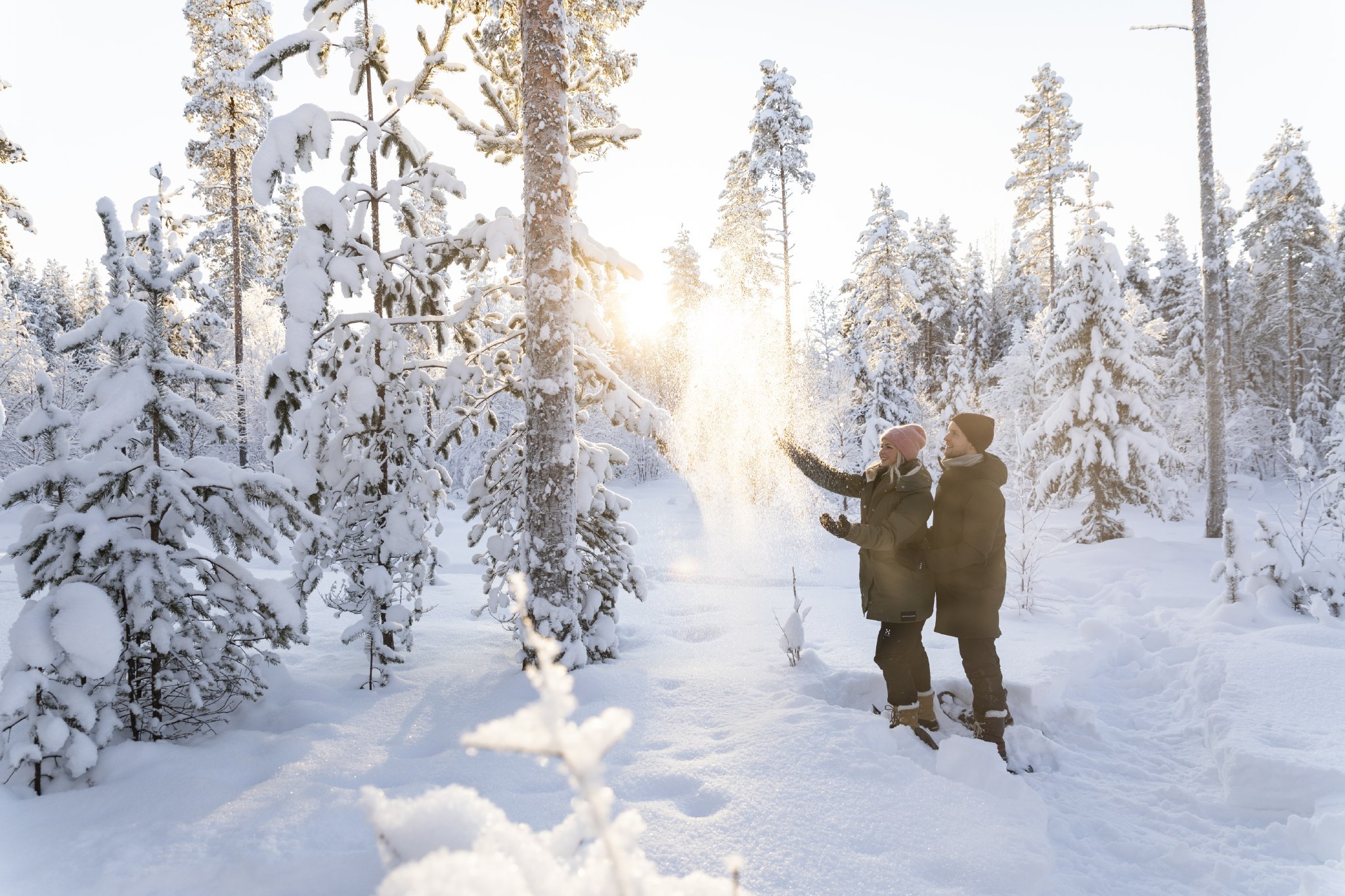 A couple snowshoeing in wintery forest in Rovaniemi