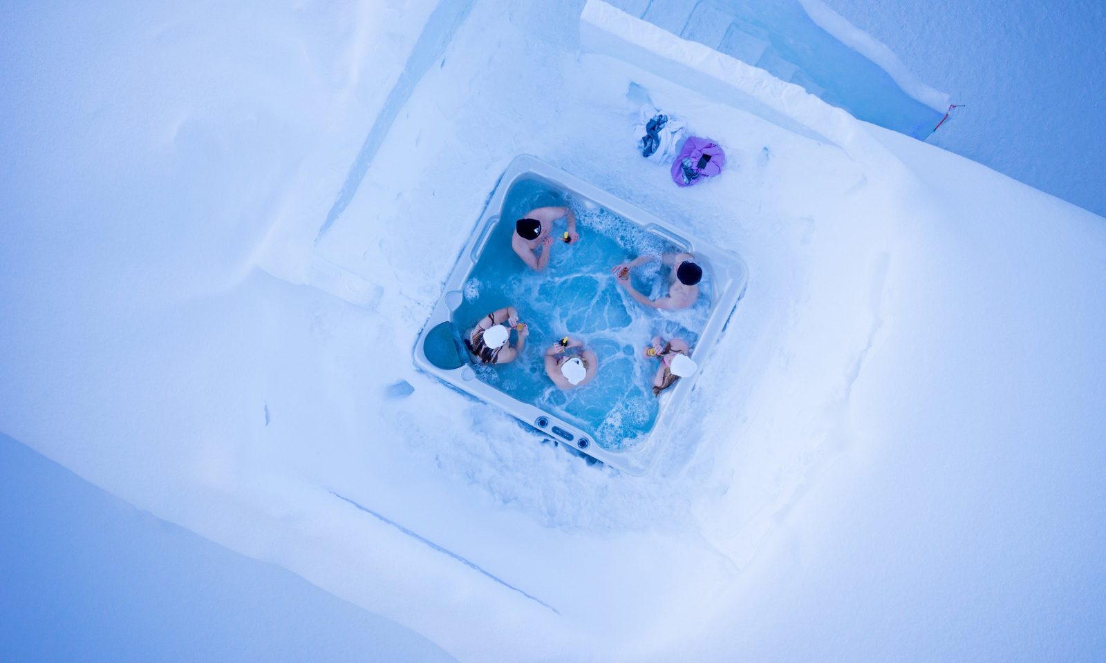 Ulkoporeallas lumen ympäröimänä ylhäältä päin kuvattuna – vieraat nauttivat juomista kylvyssä