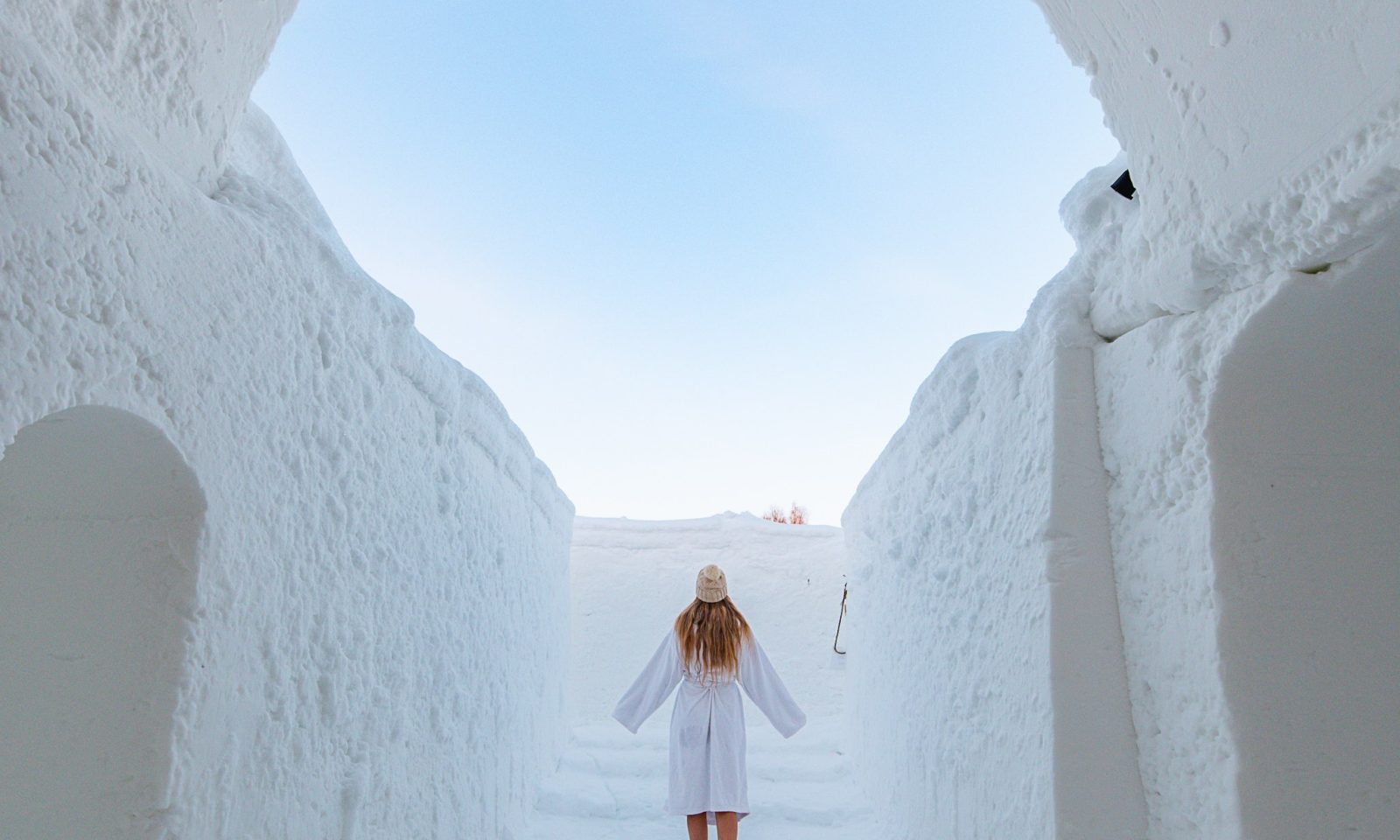 Vierailija lumisaunan käytävän edessä