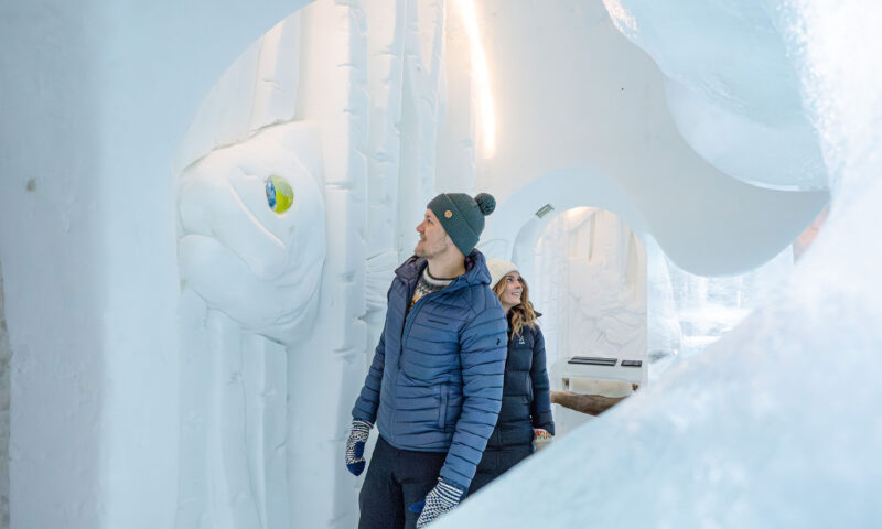 Two visitor admiring the snow art in the snow hotel