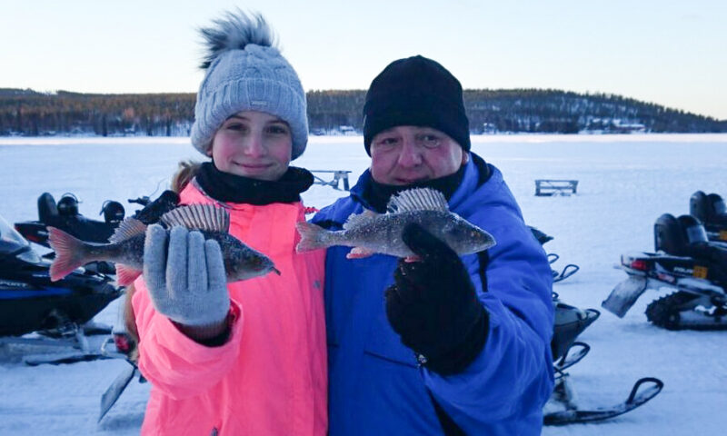 Two people showing fishes