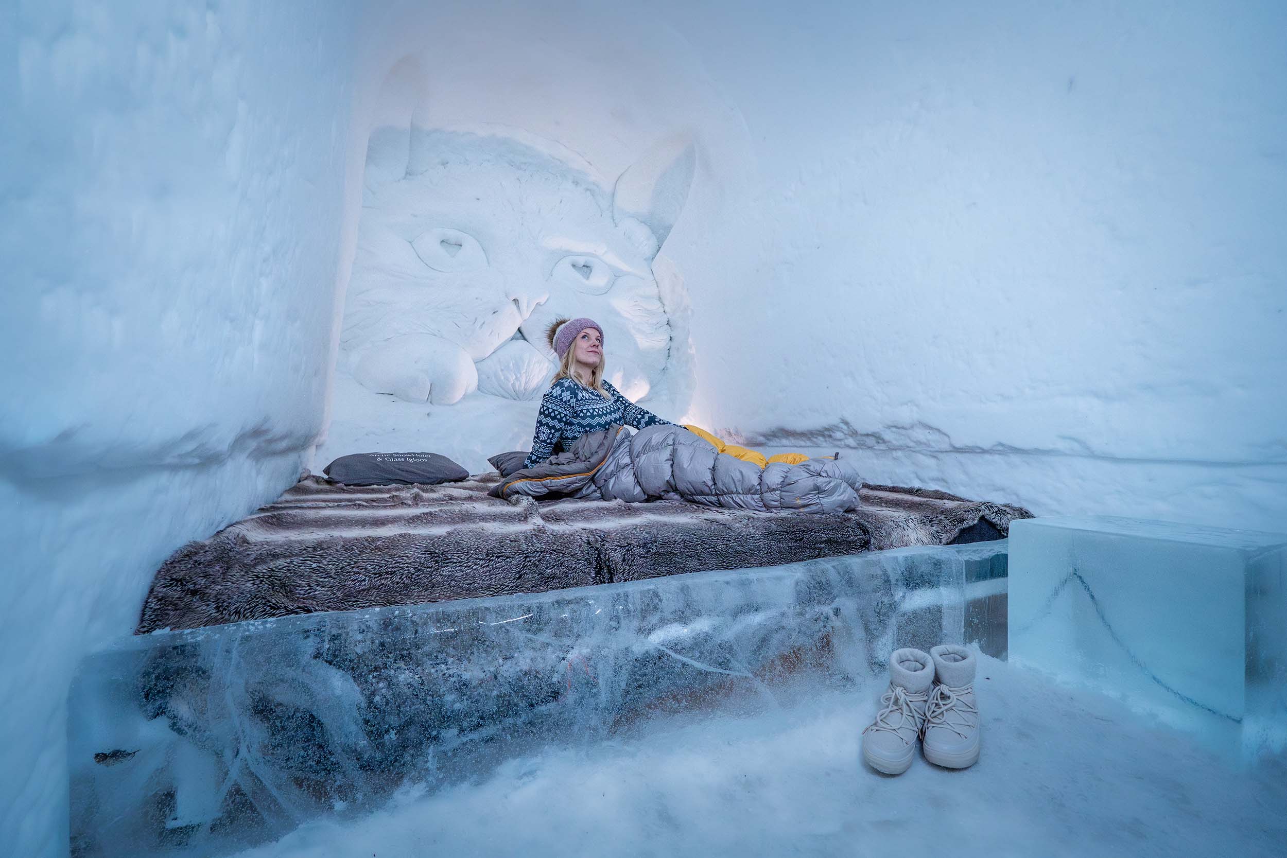 Nainen makuupussissa lumihotellin superihuoneessa