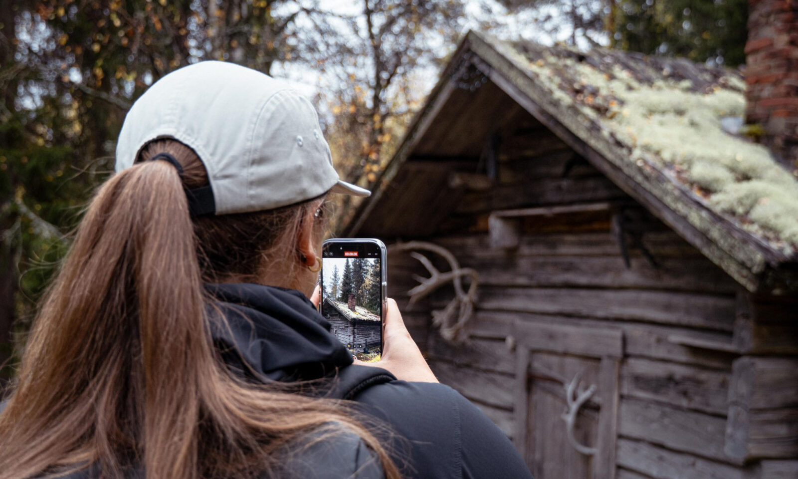 A visitor photographs a reindeer shed.