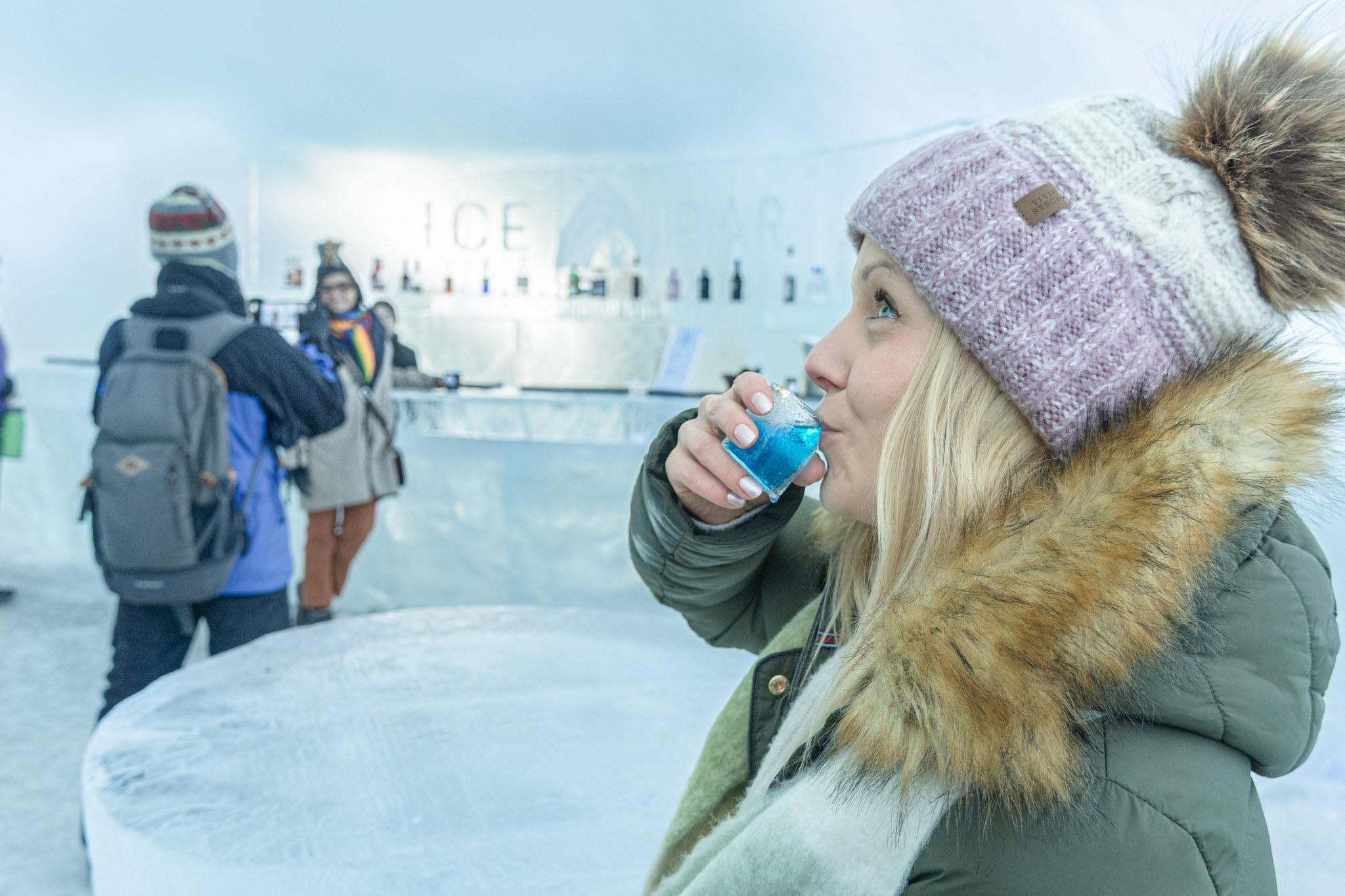 Visitor having a sip of drink in an ice glass in the Ice bar.